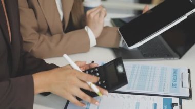 Yakın çekim - modern ofiste masa üzerinde kalem ve hesap makinesi tutan kadın elleri