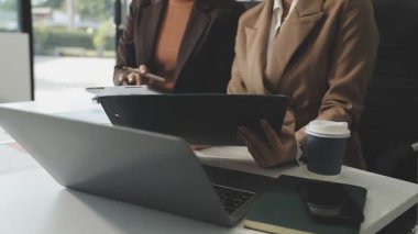 İş arkadaşı ile çalışırken dijital tablet kullanan iş kadını