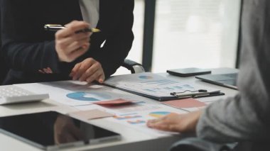 İşadamları finansal haritaları analiz ediyor ve takımlarını oluşturmak için bir tablet bilgisayar kullanıyorlar..