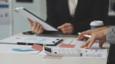 Ofiste finansal tablolar ve grafiklerle çalışan iş adamları..