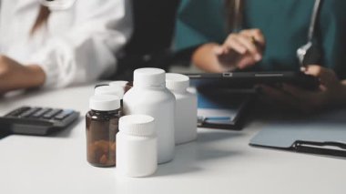 Modern ofiste ilaç şişesiyle tıbbi haplara ve steteskopa yakından bakın.