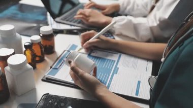 Doktor ilaç şişesini haplarla tutuyor.