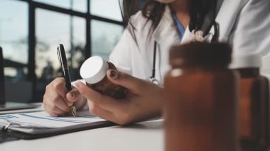 Kadın doktor hapları tutuyor.
