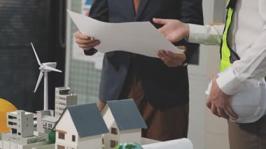 Kostüm ve mimar mühendis ve mimar planlarını tartışıyor.