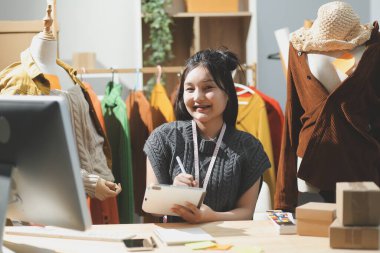 Moda tasarımcıları iş başında. Moda tasarım stüdyosunda çalışan güzel genç bir kadın..
