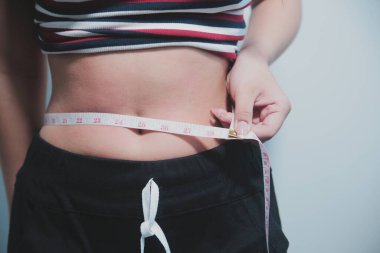 Kadın göbeği. Şişman kadın göbek yağlarını tutuyor. diyet yaşam tarzı konsepti karın kaslarını zayıflatmak ve sağlıklı mide kaslarını şekillendirmek için.