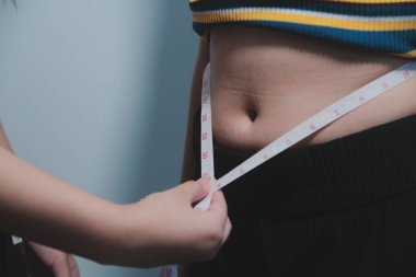 Kadın göbeği. Şişman kadın göbek yağlarını tutuyor. diyet yaşam tarzı konsepti karın kaslarını zayıflatmak ve sağlıklı mide kaslarını şekillendirmek için.