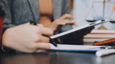 Modern bir ofisin ahşap masasında bir kalemle avukatın elini kapat.