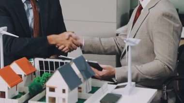 Emlakçı ve adam bir evi, gayrimenkulü, iş konseptini sallıyor.