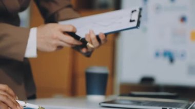 Ofiste belgeleri olan bir iş adamı bilgisayarda çalışıyor.