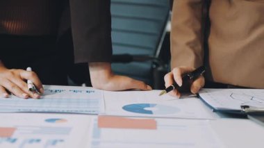 Belgeler ve finansal grafiklerle çalışan iş kadınlarını kapat