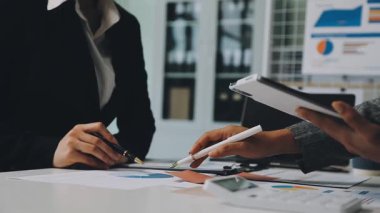 Genç Asyalı iş adamları ofiste yeni projeyi tartışıyor.