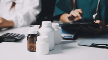 Kapalı - beyaz bir şişede ilaç hapları tutan bir doktorun ellerinde..