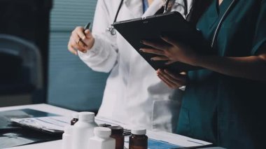 Doktor elinde tıbbi ekipmanlarla tablet bilgisayar tutuyor.