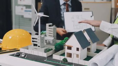 Ev planı üzerinde çalışan mimar, modelli mühendis modeli