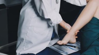 Bacak masajı yapan kadın doktorun yakın görüntüsü.