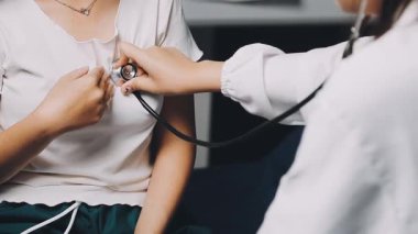 Bayan doktor kalp atışlarını kontrol ediyor.