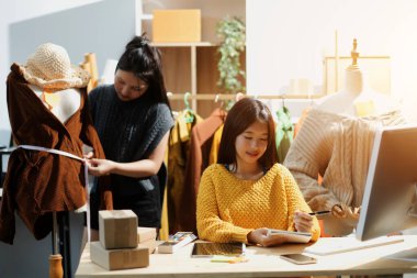 Moda tasarımcıları iş başında. Moda tasarım stüdyosunda çalışan güzel genç bir kadın..