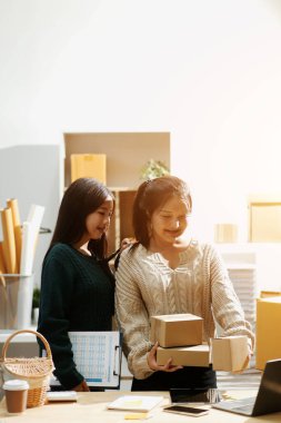 Başlangıçta küçük işletme KOBİ 'si, akıllı telefon veya tablet kullanan girişimci Afrikalı kadın paket ürün kutusu hazırlamak için çevrimiçi alışveriş siparişini alır ve kontrol eder.