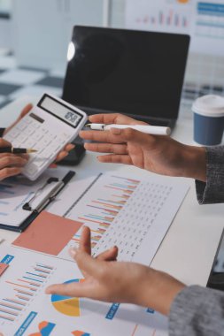Muhasebe şirketi kazançlı nakit akışı için finansman ve vergilendirme planlaması, ofiste çalışan denetçi ve muhasebeci ekibi, mali verileri ve muhasebe kayıtlarını hesap makinesiyle analiz eder.