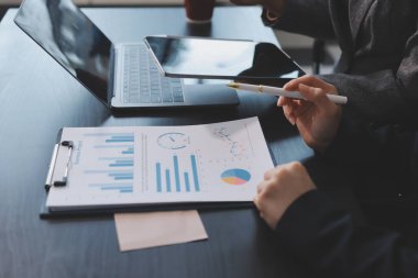 Muhasebe şirketi kazançlı nakit akışı için finansman ve vergilendirme planlaması, ofiste çalışan denetçi ve muhasebeci ekibi, mali verileri ve muhasebe kayıtlarını hesap makinesiyle analiz eder.