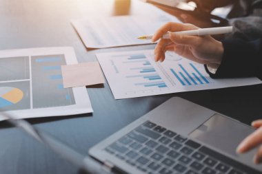 Muhasebe şirketi kazançlı nakit akışı için finansman ve vergilendirme planlaması, ofiste çalışan denetçi ve muhasebeci ekibi, mali verileri ve muhasebe kayıtlarını hesap makinesiyle analiz eder.