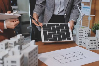 İş adamları arasında güneş pili paneli teknolojisi ve Güneş Enerjisi Çevre Kenti kavramındaki son gelişmeler üzerine tartışma.