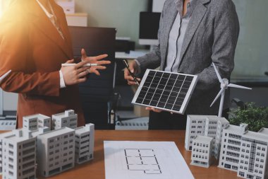 İş adamları arasında güneş pili paneli teknolojisi ve Güneş Enerjisi Çevre Kenti kavramındaki son gelişmeler üzerine tartışma.