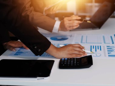 Muhasebe şirketi kazançlı nakit akışı için finansman ve vergilendirme planlaması, ofiste çalışan denetçi ve muhasebeci ekibi, mali verileri ve muhasebe kayıtlarını hesap makinesiyle analiz eder.