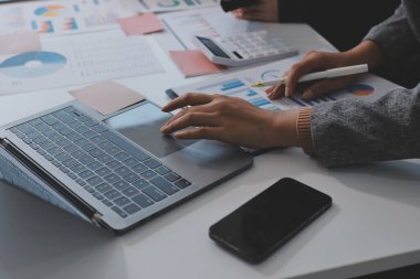 Muhasebe şirketi kazançlı nakit akışı için finansman ve vergilendirme planlaması, ofiste çalışan denetçi ve muhasebeci ekibi, mali verileri ve muhasebe kayıtlarını hesap makinesiyle analiz eder.