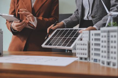 İş adamları arasında güneş pili paneli teknolojisi ve Güneş Enerjisi Çevre Kenti kavramındaki son gelişmeler üzerine tartışma.