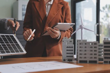 İş adamları arasında güneş pili paneli teknolojisi ve Güneş Enerjisi Çevre Kenti kavramındaki son gelişmeler üzerine tartışma.