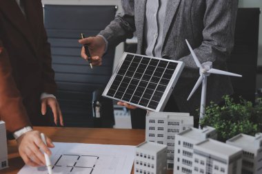 İş adamları arasında güneş pili paneli teknolojisi ve Güneş Enerjisi Çevre Kenti kavramındaki son gelişmeler üzerine tartışma.