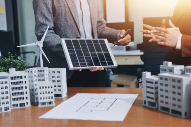 İş adamları arasında güneş pili paneli teknolojisi ve Güneş Enerjisi Çevre Kenti kavramındaki son gelişmeler üzerine tartışma.