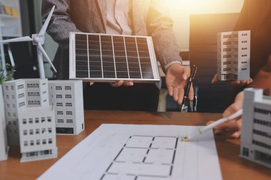 İş adamları arasında güneş pili paneli teknolojisi ve Güneş Enerjisi Çevre Kenti kavramındaki son gelişmeler üzerine tartışma.