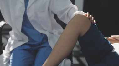 Doktor ofiste hasta bacağını kontrol ediyor.