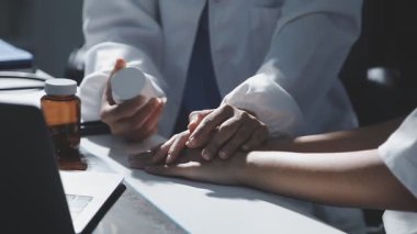 Kapat. Beyaz önlüklü doktor hastanede elini tutuyor.
