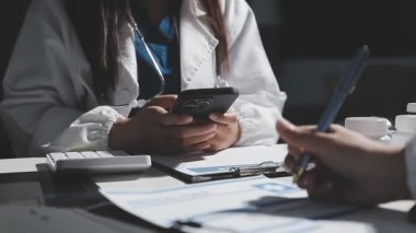 Doktor tableti tutuyor ve hastanın ellerini kontrol ediyor..