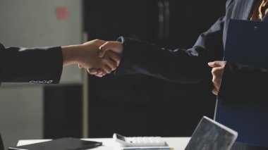 İş adamı, ortak, iş ortağı, başarı ve ortaklık kavramı ile modern ofiste yaptığı toplantı sonrasında el sıkışıyor
