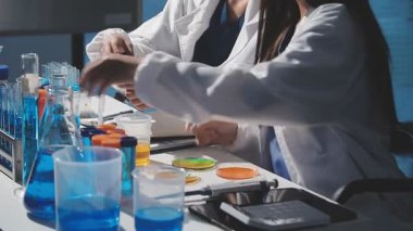 Test tüpleriyle çalışan kadın laboratuvar çalışanı.