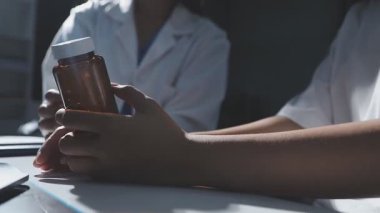 Doktor el hapları tutuyor.