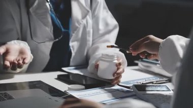 Kapat. Doktorlar modern bir ofiste tabletle çalışıyorlar.