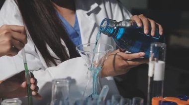 Laboratuvarda bir test tüpü tutan kadın bilim adamı.