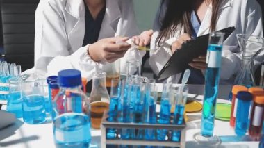 Laboratuvarda çalışan üniformalı genç kadın bilim adamı..