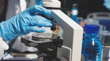 Laboratuvardaki bilim adamı elinde sıvı olan test tüpünü tutuyor.