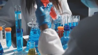 Laboratuvarda test tüpleriyle çalışan bilim adamlarının yakın plan görüntüleri.