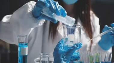 Laboratuvarda kimya laboratuvarında çalışan genç bir kadın.