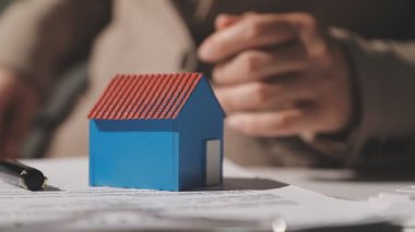 Beyaz arka planda mavi bir kalem tutan bir adam.