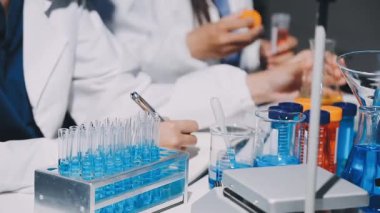 Bir laboratuarda elinde tüpü tutan genç bir kadın bilim adamı..