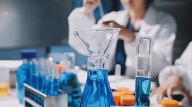 Laboratuvarda kimyasal sıvıyla dolu laboratuvar bardakları..